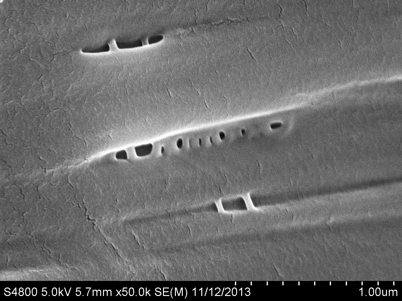 High-magnification SEM micrograph showing microvoids in a synthetic fibre
